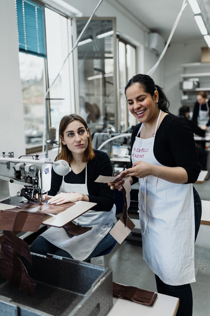 ragazze sorridenti che stanno eseguenzo la materia del corso macchine da cucito